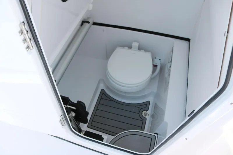 Slide: The Image of 2025 Sportsman Open 262 Center Console boat interior with compact marine toilet. - 12