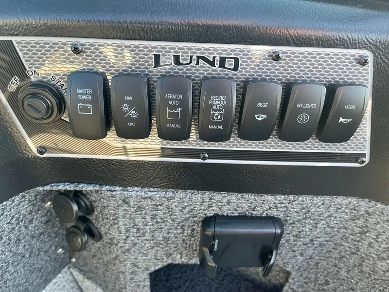 Slide: The Image of Control panel of 2025 Lund 1775 Impact XS Sport boat with various switches. - 19