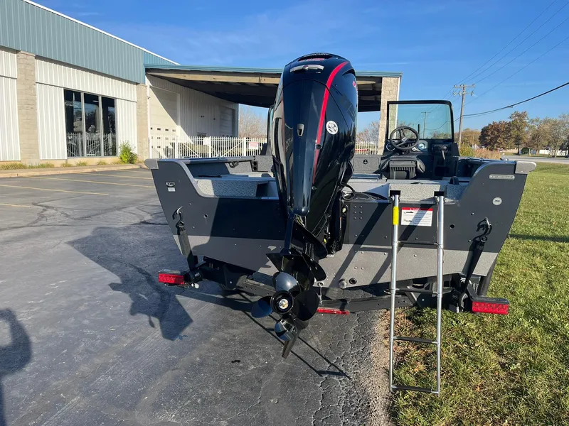 Slide: The Image of 2025 Lund 1775 Impact XS Sport boat with outboard motor, parked outdoors. - 4