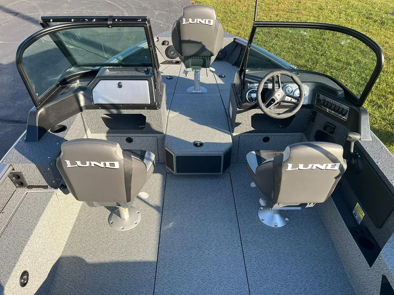 Slide: The Image of 2025 Lund 1775 Impact XS Sport boat interior with three seats and steering console. - 6
