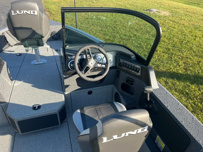 Slide: The Image of 2025 Lund 1775 Impact XS Sport boat interior with steering wheel and seating. - 9