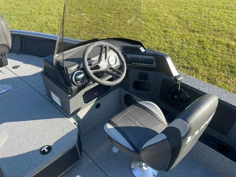 Slide: The Image of 2025 Lund 1775 Impact XS SS boat interior with steering wheel and seating. - 11