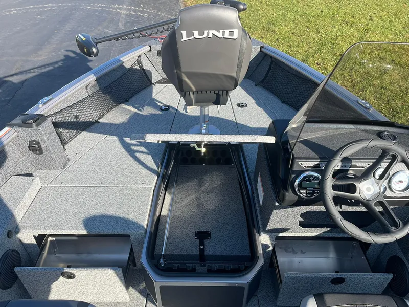 Slide: The Image of 2025 Lund 1775 Impact XS SS boat interior with storage compartments and steering wheel. - 13