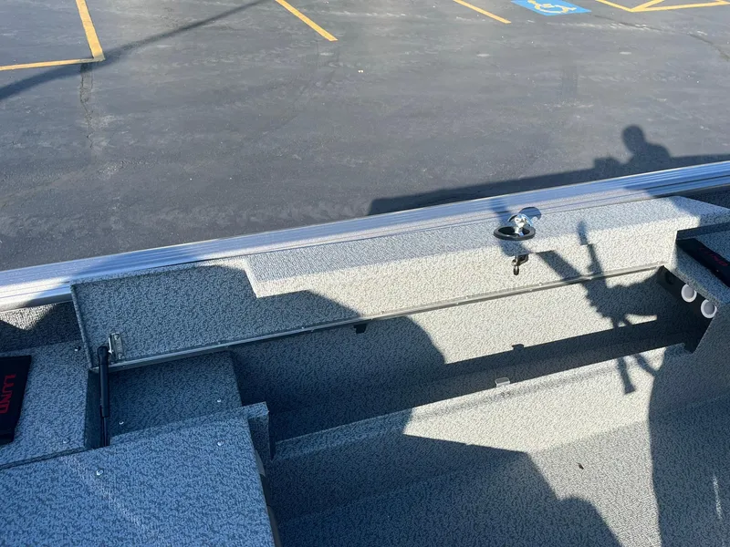 Slide: The Image of 2025 Lund 1775 Impact XS SS boat interior with textured flooring in a parking lot. - 19