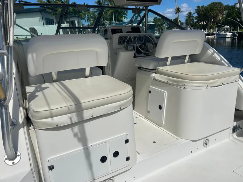Slide: The Image of 1999 Wellcraft 330 Coastal boat interior with white seating and control panel. - 11