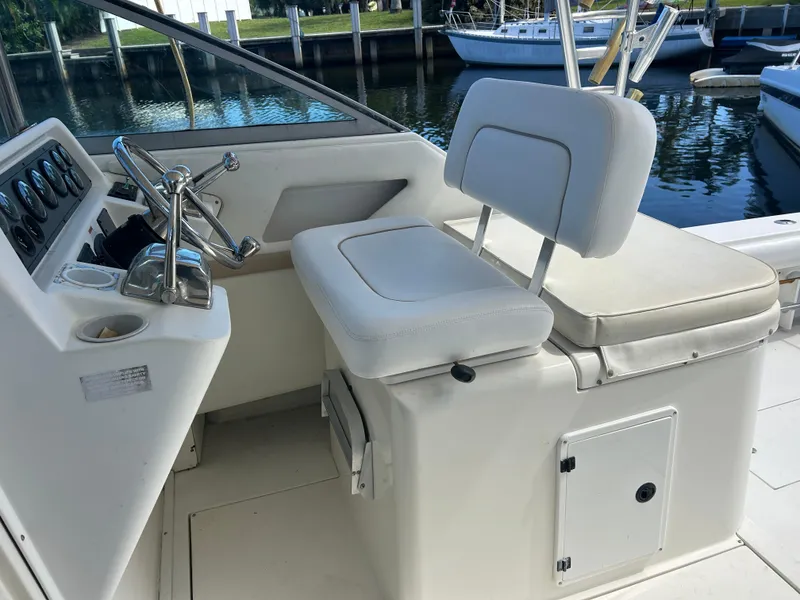 Slide: The Image of 1999 Wellcraft 330 Coastal boat helm with white seating and control panel. - 23