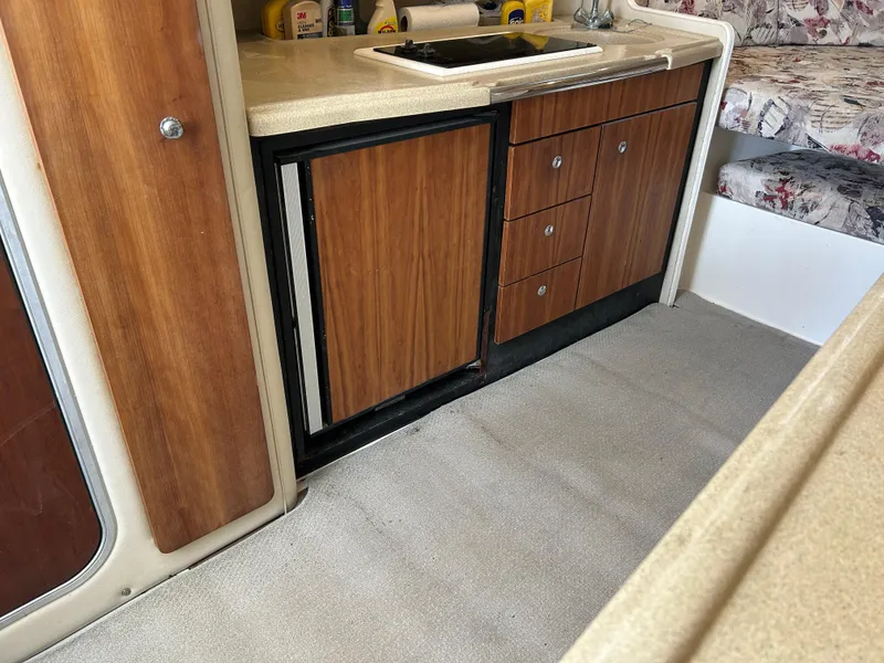 Slide: The Image of 1999 Wellcraft 330 Coastal interior with wood cabinets and compact kitchen area. - 27