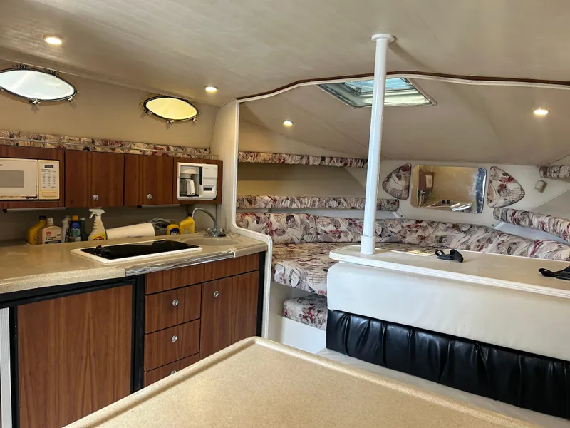 Slide: The Image of 1999 Wellcraft 330 Coastal cabin interior with kitchenette and seating area. - 30