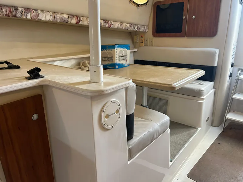 Slide: The Image of 1999 Wellcraft 330 Coastal cabin interior with dining area and seating. - 47