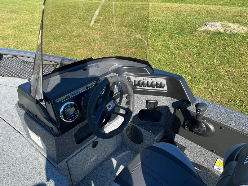 Slide: The Image of 2025 Lund 1875 Impact XS SS boat dashboard with steering wheel and controls. - 13