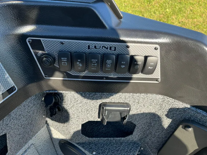 Slide: The Image of Control panel of 2025 Lund 1875 Impact XS SS boat, featuring multiple switches. - 14