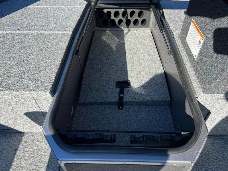 Slide: The Image of 2025 Lund 1875 Impact XS SS boat storage compartment with rod holders. - 17