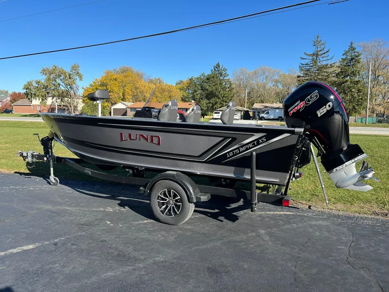 Slide: The Image of 2025 Lund 1875 Impact XS SS boat on trailer, parked outdoors. - 3