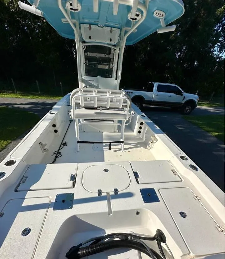 Slide: The Image of 2022 NauticStar 249 XTS boat with spacious deck and seating, parked near a white truck. - 10