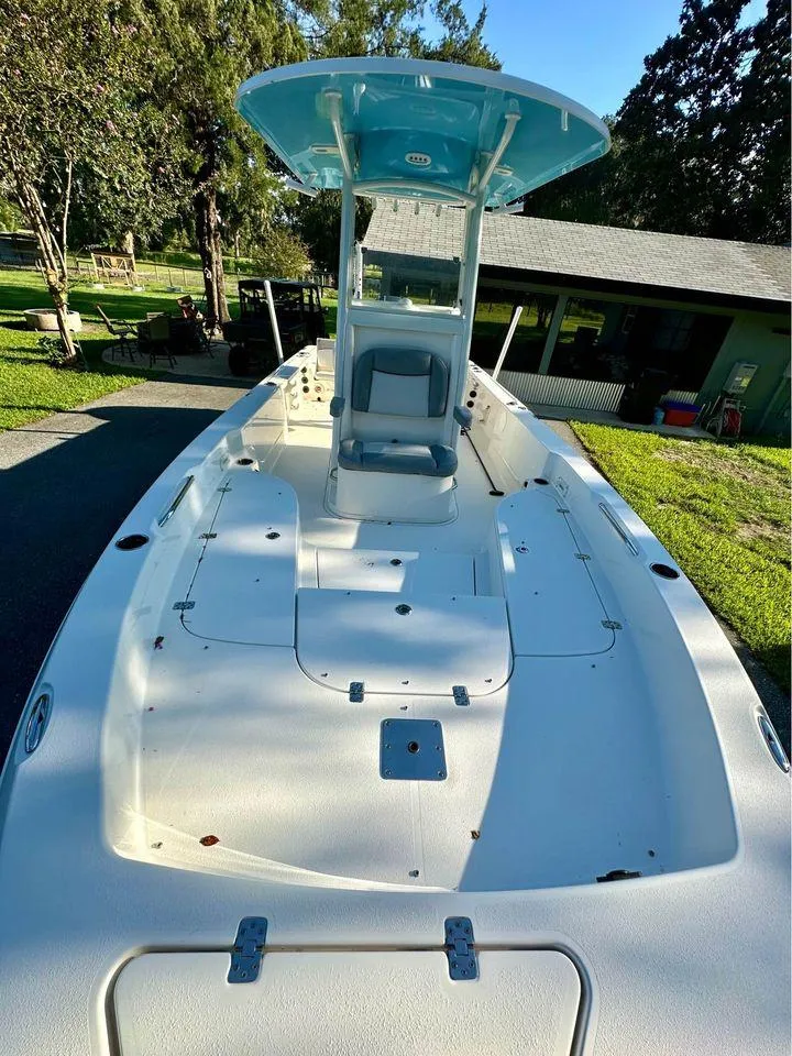 Slide: The Image of 2022 NauticStar 249 XTS boat with spacious deck and T-top in a sunny outdoor setting. - 2