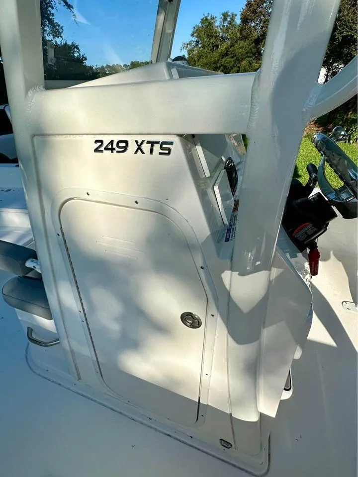 Slide: The Image of 2022 NauticStar 249 XTS boat console with steering wheel and storage compartment. - 3