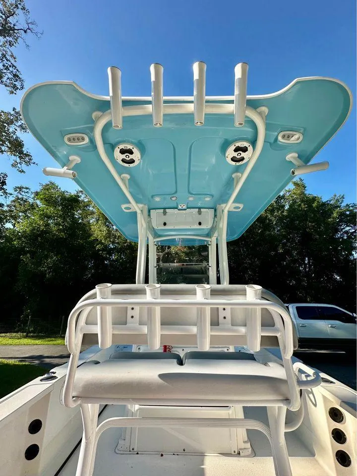 Slide: The Image of 2022 NauticStar 249 XTS boat with blue T-top and rod holders, viewed from the rear. - 6