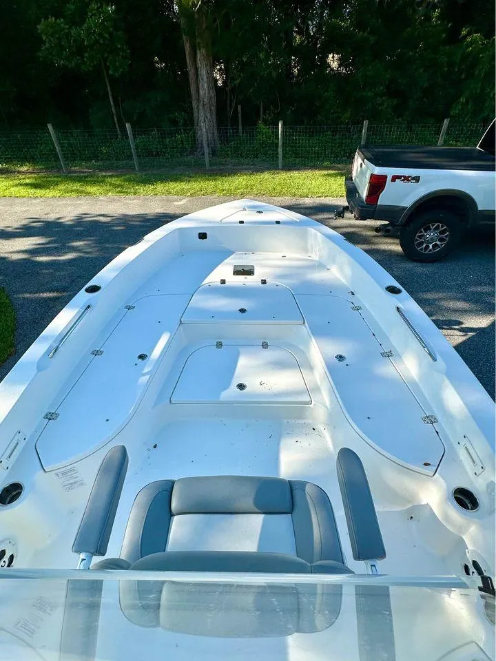 Slide: The Image of 2022 NauticStar 249 XTS boat, white deck, parked near a truck. - 7