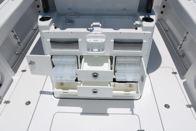 Slide: The Image of 2025 Sportsman Open 282 boat storage compartments with open drawers and tackle boxes. - 11
