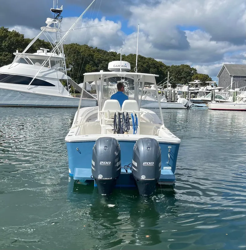 Slide: The Image of 2014 Regulator 25FS Center Console boat with twin engines in a marina. - 2