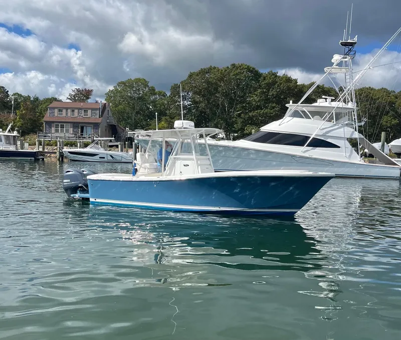 Slide: The Image of 2014 Regulator 25FS Center Console boat on calm water near docks. - 3