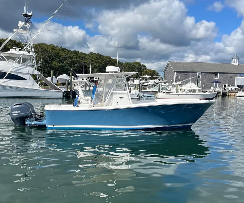 Slide: The Image of 2014 Regulator 25FS Center Console boat on calm water, under a partly cloudy sky. - 4