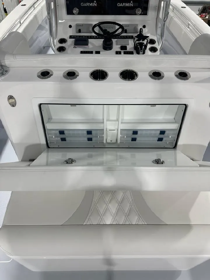 Slide: The Image of 2024 Contender 39 ST boat interior with open storage compartment and Garmin electronics. - 6