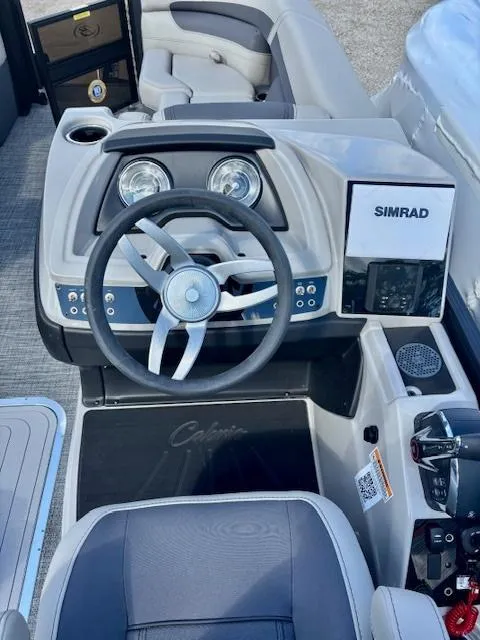 Slide: The Image of 2025 Barletta C22UC boat dashboard with steering wheel and Simrad display. - 4