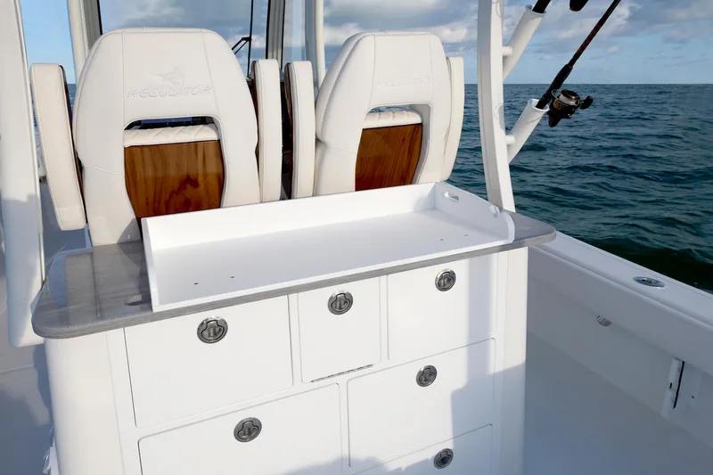 Slide: The Image of 2026 Regulator 30XO boat interior with seating and storage, ocean backdrop. - 5