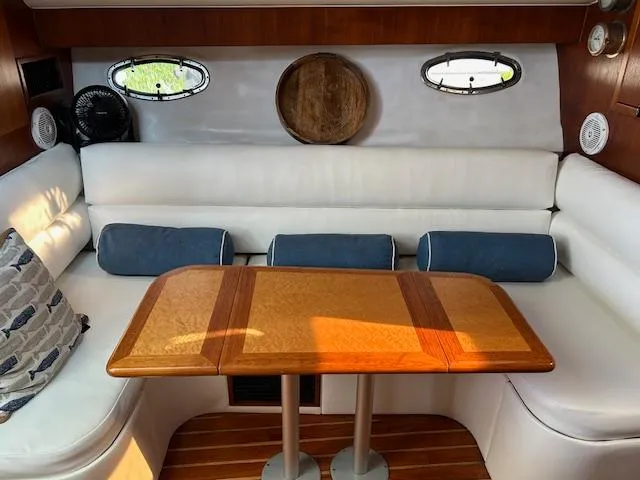 Slide: The Image of Interior of 2000 Tiara Yachts 3700 Open with white seating and wooden table. - 30
