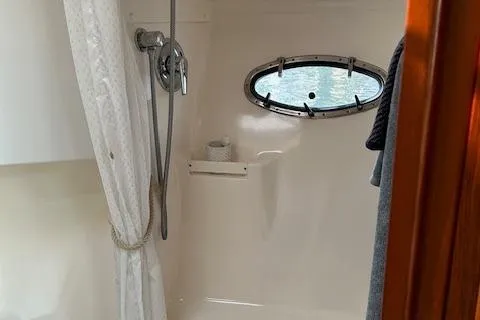 Slide: The Image of Shower area in 2000 Tiara Yachts 3700 Open, featuring a porthole and curtain. - 35