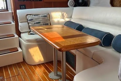 Slide: The Image of Interior of 2000 Tiara Yachts 3700 Open with wooden table and white seating. - 37
