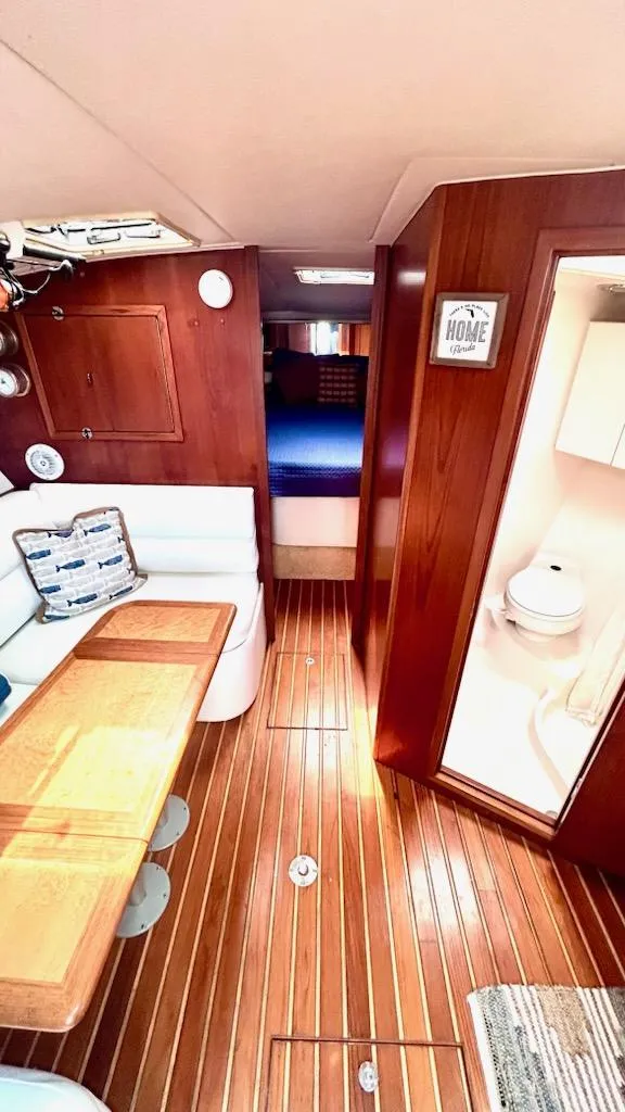 Slide: The Image of Interior of 2000 Tiara Yachts 3700 Open, featuring wood paneling and cozy seating area. - 38
