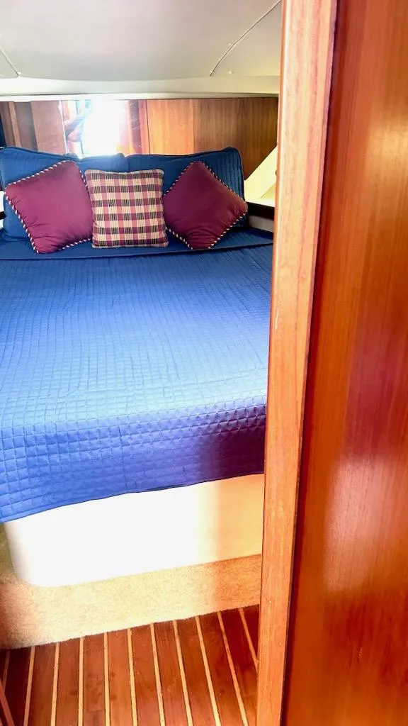 Slide: The Image of 2000 Tiara Yachts 3700 Open cabin with blue bedding and decorative pillows. - 39