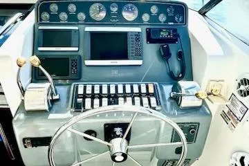 Slide: The Image of Control panel of 2000 Tiara Yachts 3700 Open with navigation instruments and steering wheel. - 9
