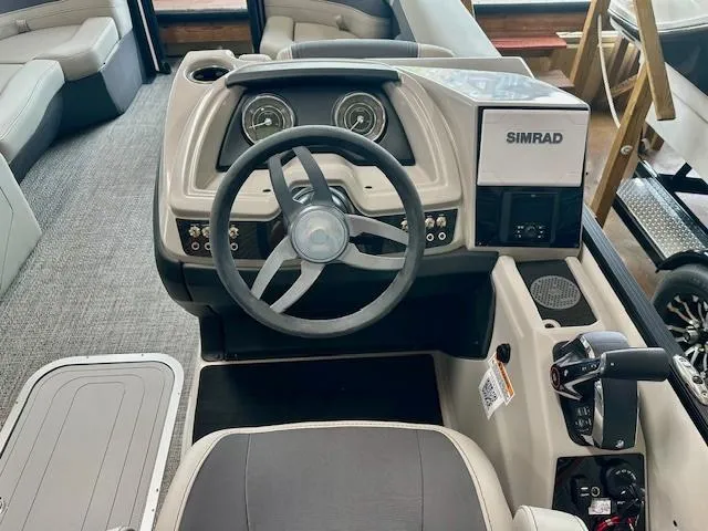 Slide: The Image of 2025 Barletta C22UC boat dashboard with steering wheel and Simrad navigation system. - 3