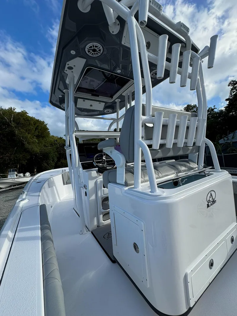 Slide: The Image of 2025 Blazer 2700 Hybrid Bay boat with tower, sleek design, white exterior, under blue sky. - 13
