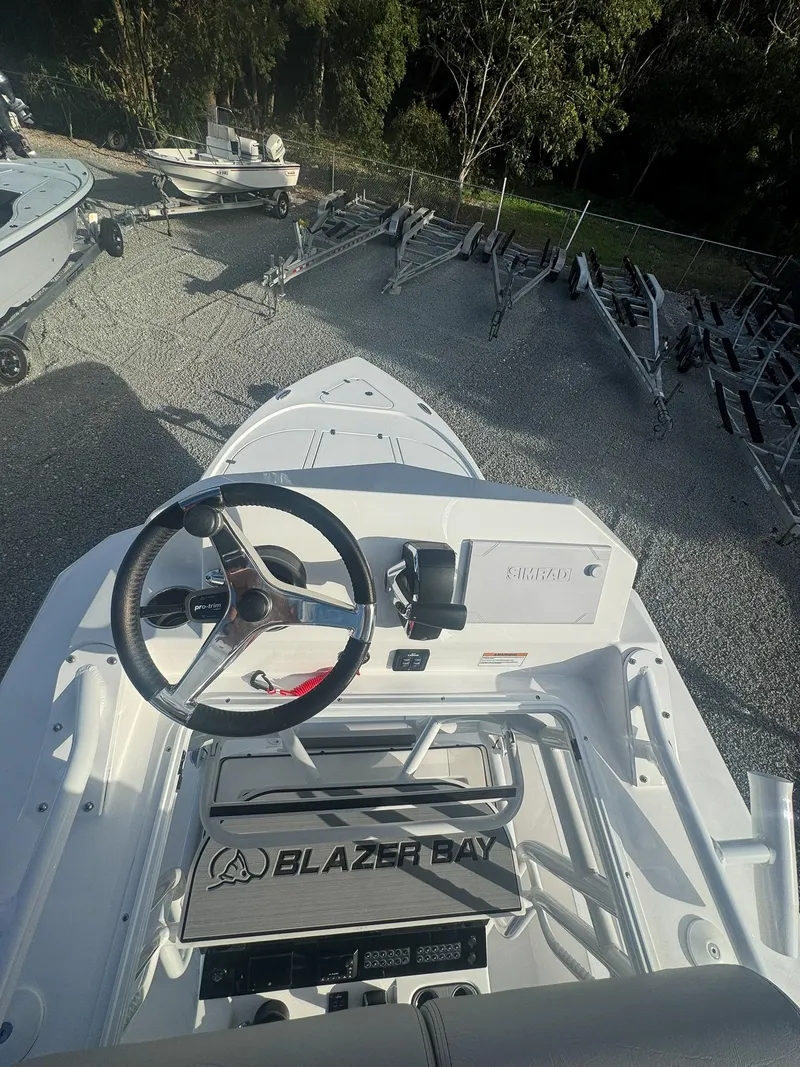 Slide: The Image of 2025 Blazer 2700 Hybrid Bay boat with tower, steering wheel, and control panel. - 16