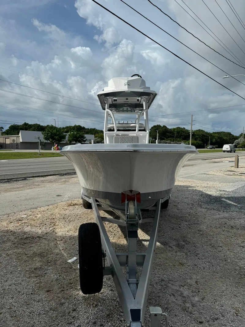 Slide: The Image of 2025 Blazer 2700 Hybrid Bay boat with tower on trailer, parked outdoors. - 3