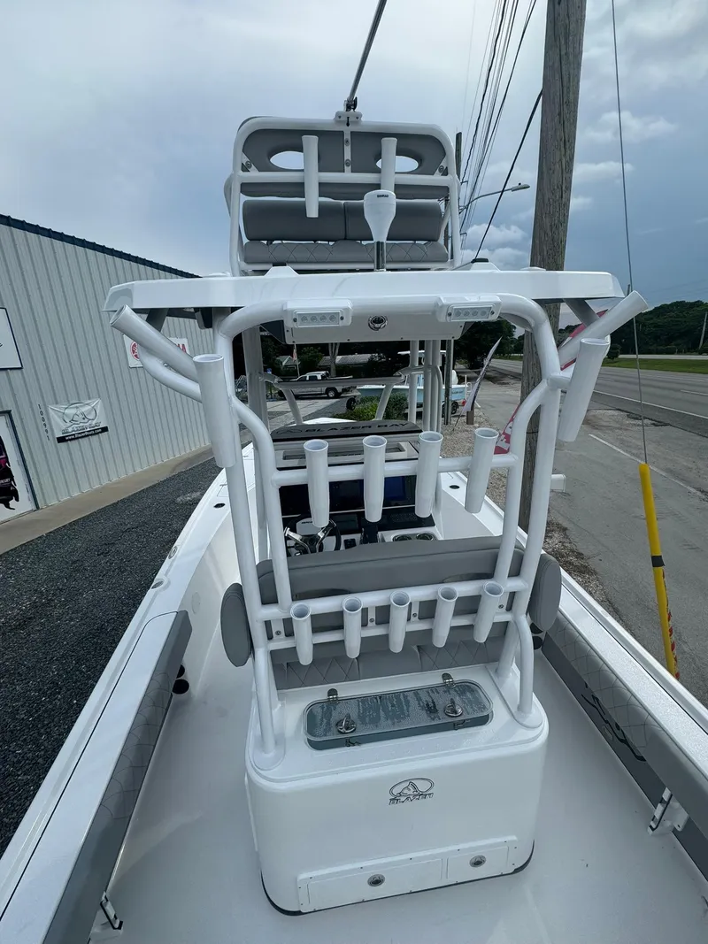 Slide: The Image of 2025 Blazer 2700 HYBRID BAY boat with tower, docked near a road. - 7