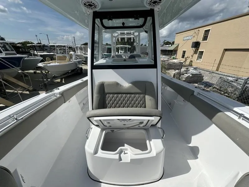 Slide: The Image of 2025 Sportsman Open 282 boat interior with seating and storage, docked at a marina. - 13