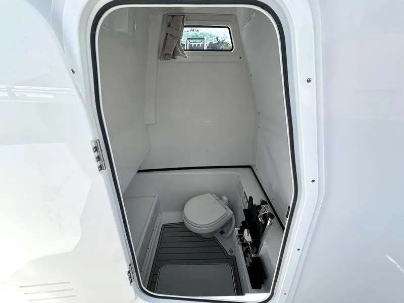 Slide: The Image of 2025 Sportsman Open 282 boat interior bathroom with toilet and window. - 15