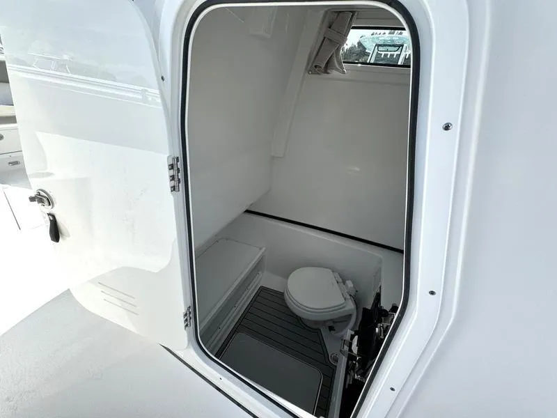 Slide: The Image of 2025 Sportsman Open 282 boat interior with compact marine toilet. - 16
