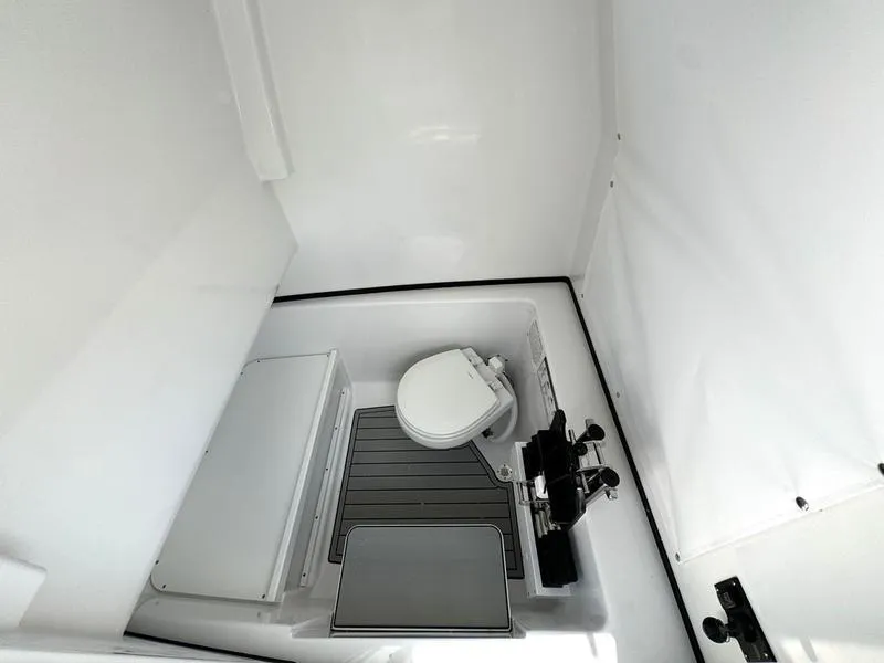 Slide: The Image of 2025 Sportsman Open 282 boat interior with toilet and storage area. - 18