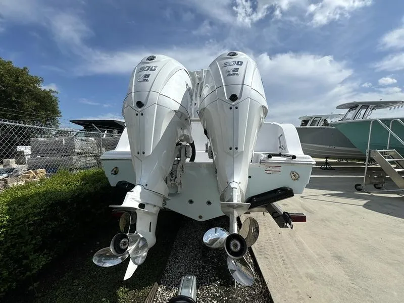 Slide: The Image of 2025 Sportsman Open 282 boat with dual outboard engines, parked outdoors. - 2