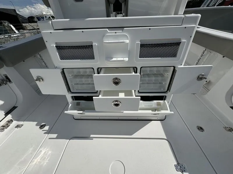 Slide: The Image of 2025 Sportsman Open 282 boat storage compartments with open drawers and doors. - 35
