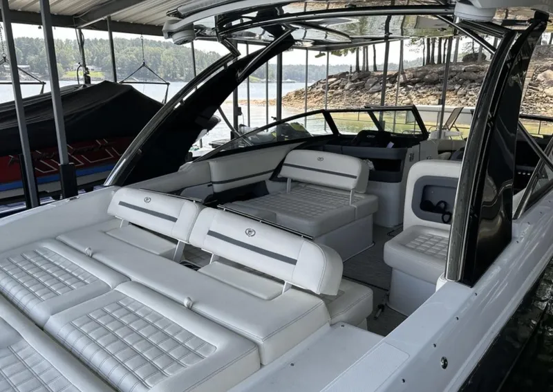 Slide: The Image of 2022 Cobalt R30 boat with luxurious white seating, docked by a scenic lakeside. - 20