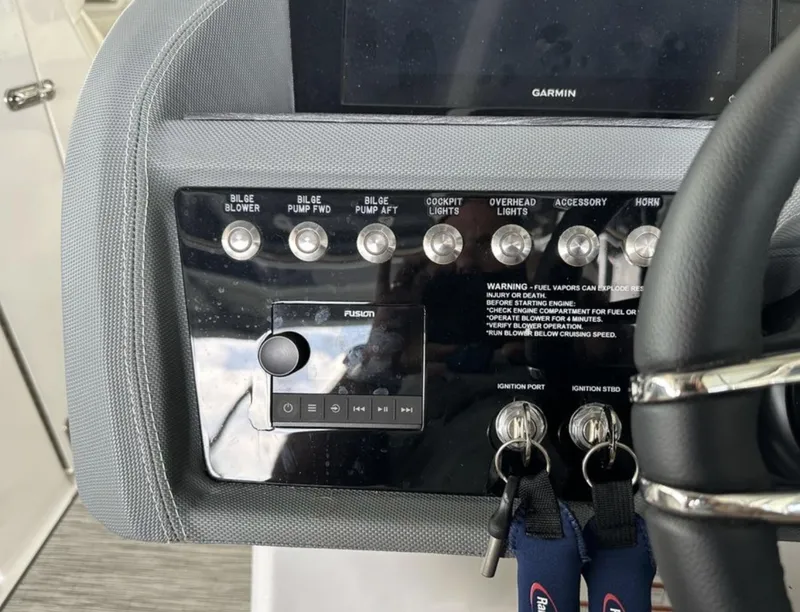 Slide: The Image of Control panel of a 2022 Cobalt R30 boat with various switches and a Fusion audio system. - 6