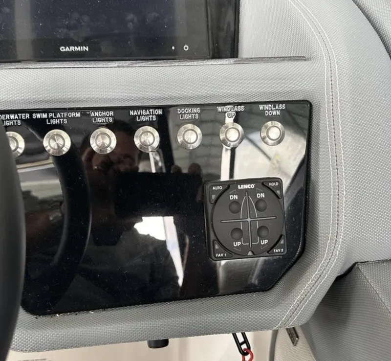 Slide: The Image of Control panel of a 2022 Cobalt R30 boat with various light switches and a Lenco trim tab. - 7