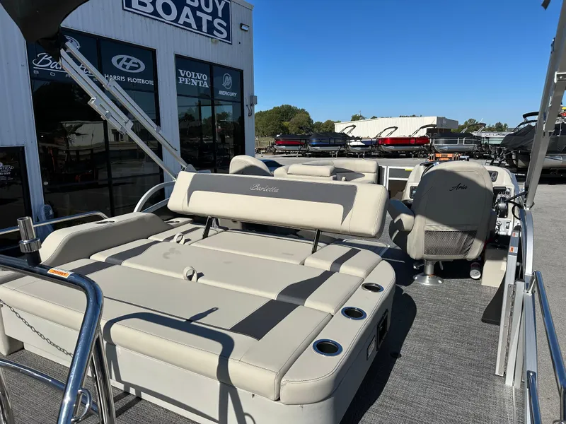 Slide: The Image of 2024 Barletta A20UC pontoon boat with beige seating at a dealership. - 13